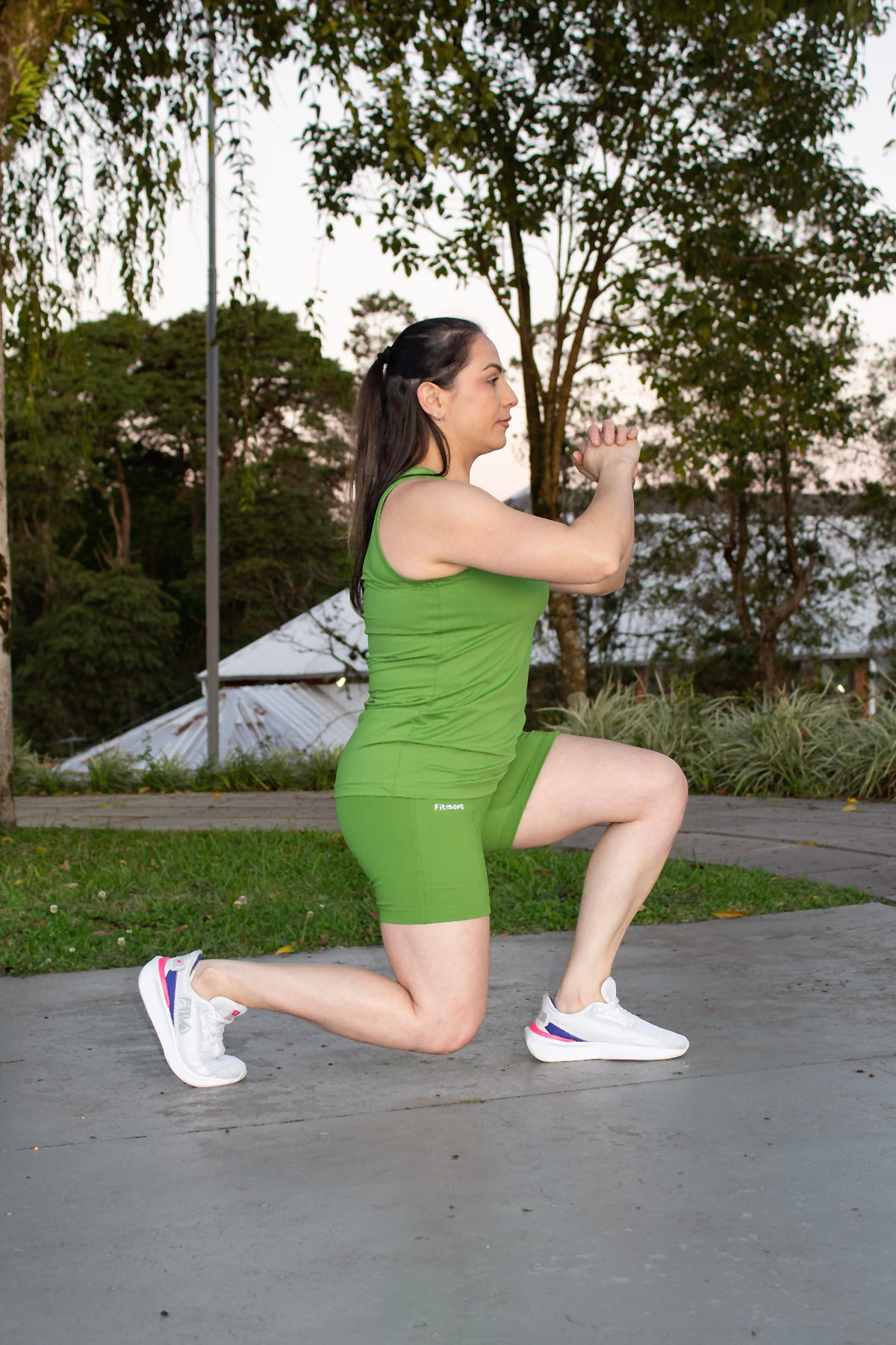 Modelo fazendo avanço com regata e short verdes Fitmora